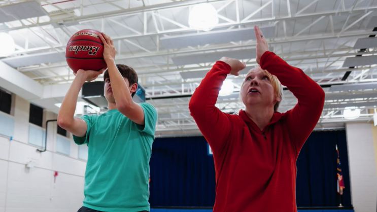 Krista Gingrich-White, Perfec'Shot founder, demonstrating proper form to young basketball player