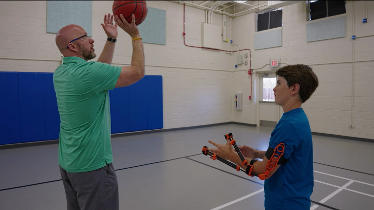 Rob White, Perfec'Shot founder, giving a young player instruction in proper basketball shooting form